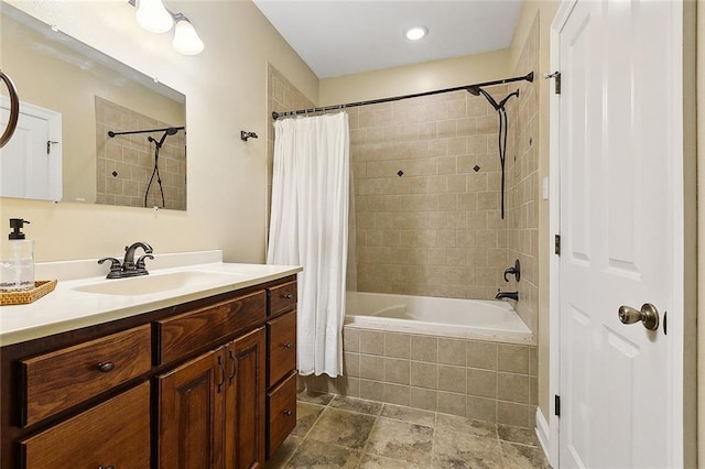 bathroom featuring tiled shower / bath and vanity