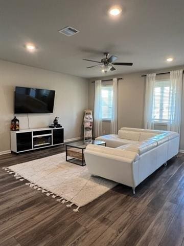 living room with plenty of natural light, visible vents, dark wood finished floors, and baseboards