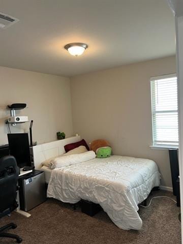 bedroom featuring visible vents and dark colored carpet