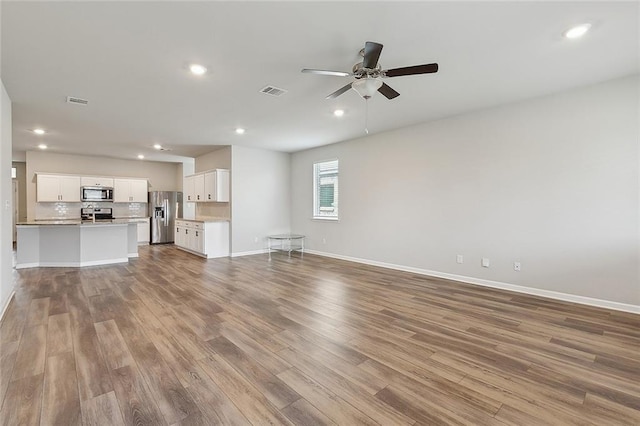 5635 Oak Trace Dr, Saint Gabriel, LA 70776 - unfurnished living room featuring wood finished floors, ceiling fan, recessed lighting, and baseboards