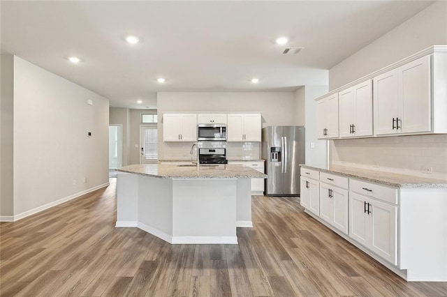 5635 Oak Trace Dr, Saint Gabriel, LA 70776 - kitchen featuring stainless steel appliances, backsplash, light wood finished floors, white cabinetry, and recessed lighting