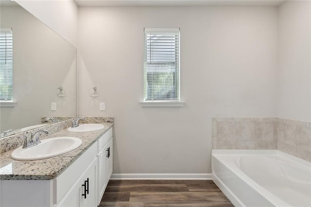 5635 Oak Trace Dr, Saint Gabriel, LA 70776 - full bathroom featuring plenty of natural light, double vanity, a garden tub, and wood finished floors