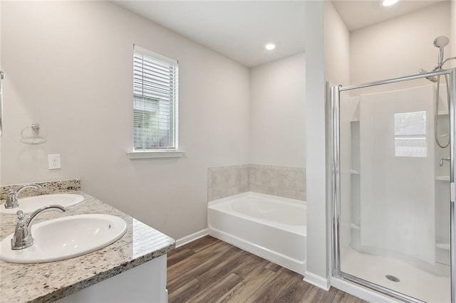 5635 Oak Trace Dr, Saint Gabriel, LA 70776 - full bathroom featuring a garden tub, a shower stall, wood finished floors, baseboards, and double vanity