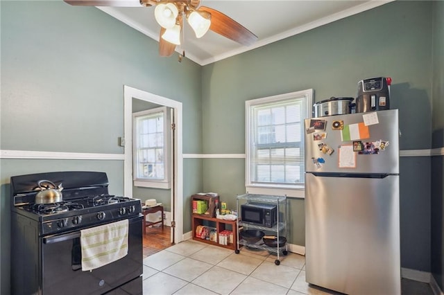 kitchen with light tile patterned floors, black appliances, ceiling fan, and baseboards