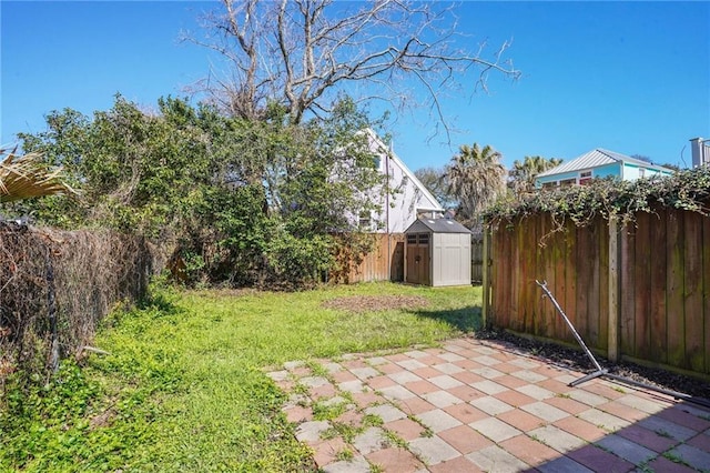 view of yard featuring a shed, a fenced backyard, a patio, and an outdoor structure