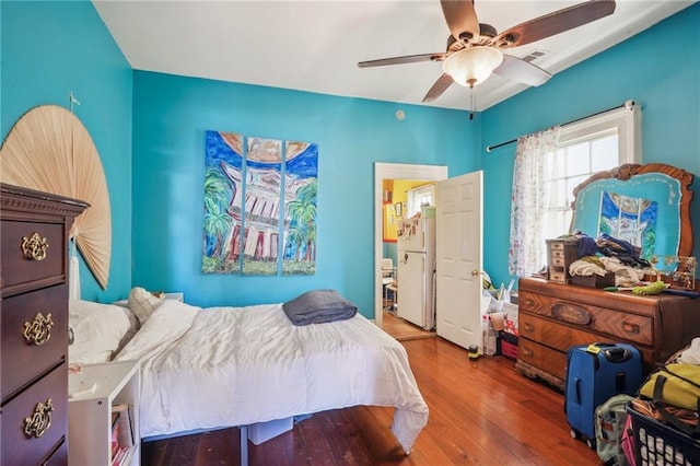 bedroom featuring ceiling fan, wood finished floors, and visible vents