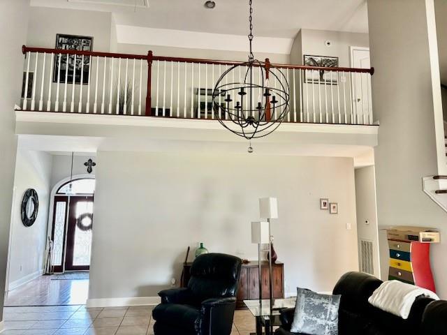 209 Legrande Bayou Ln, Kenner, LA 70065 - living room featuring a towering ceiling, tile patterned flooring, visible vents, and baseboards