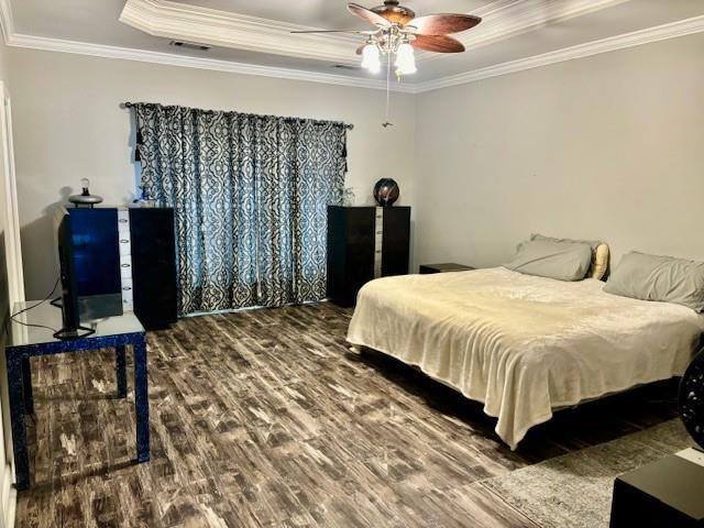 209 Legrande Bayou Ln, Kenner, LA 70065 - bedroom featuring a tray ceiling, wood finished floors, and crown molding