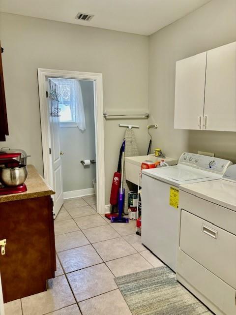 209 Legrande Bayou Ln, Kenner, LA 70065 - washroom with light tile patterned floors, visible vents, baseboards, cabinet space, and washing machine and clothes dryer