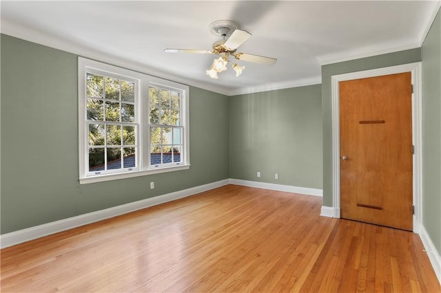 spare room with light wood-style flooring, baseboards, ceiling fan, and crown molding