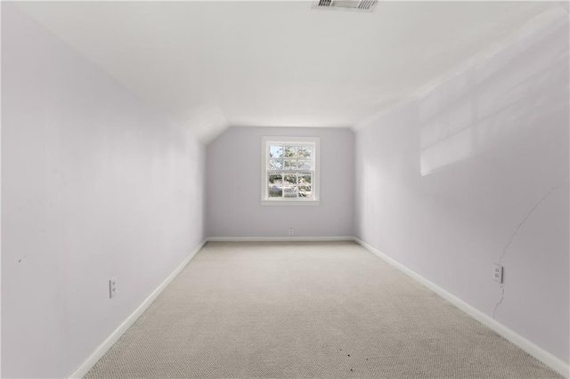 bonus room featuring lofted ceiling, carpet, and baseboards