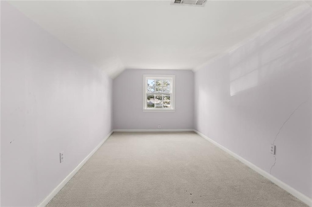 additional living space with carpet, lofted ceiling, and baseboards