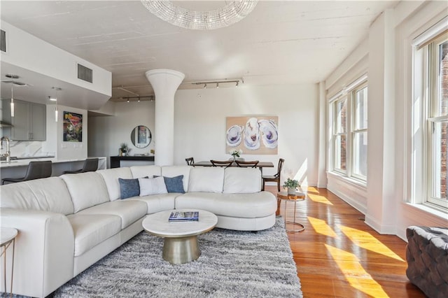 living room with rail lighting, visible vents, and wood finished floors