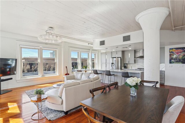 living area with visible vents, baseboards, and wood finished floors