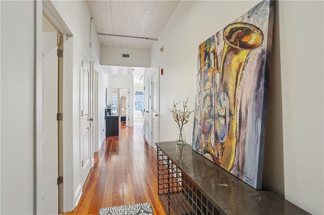 hallway featuring visible vents and hardwood / wood-style floors