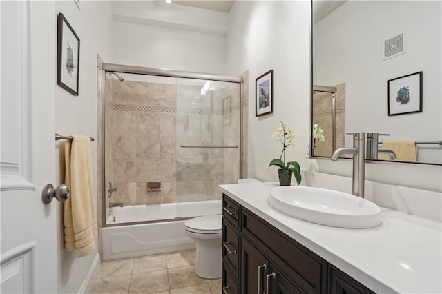 bathroom with visible vents, toilet, tile patterned floors, combined bath / shower with glass door, and vanity