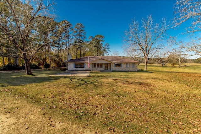 single story home featuring a chimney, a front lawn, and a patio