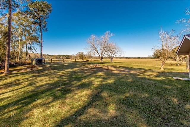 view of yard featuring a rural view and fence