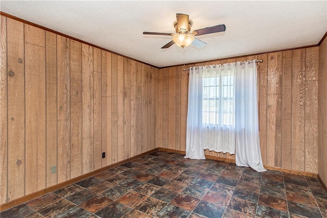 unfurnished room with wooden walls, stone finish floor, and a textured ceiling