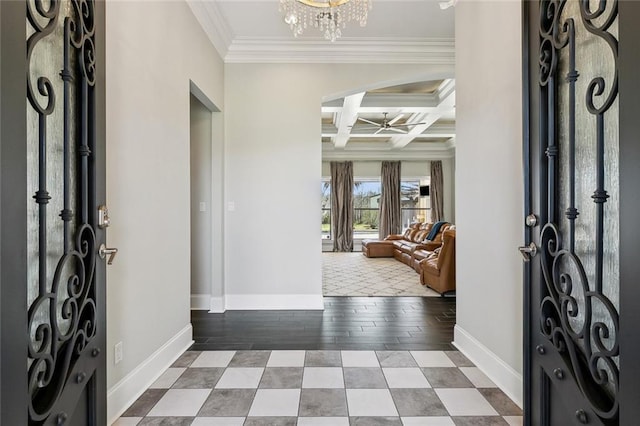 foyer with baseboards, coffered ceiling, crown molding, beam ceiling, and ceiling fan with notable chandelier