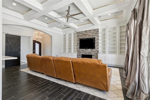 living room featuring arched walkways, a barn door, ceiling fan with notable chandelier, and beam ceiling