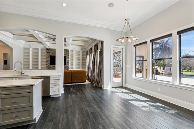 interior space with dark wood-style flooring, coffered ceiling, a sink, baseboards, and crown molding