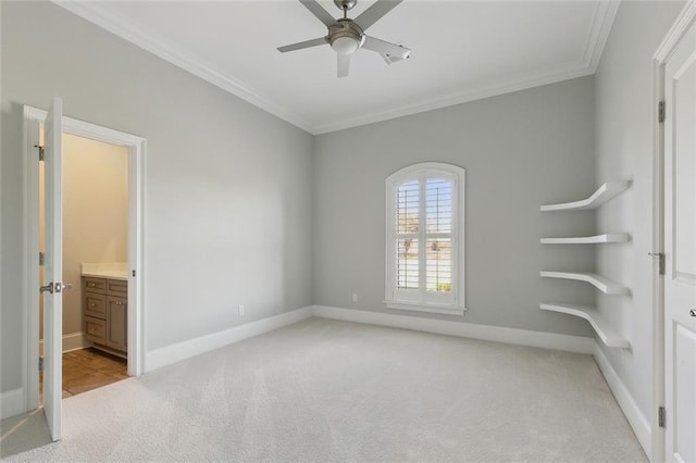 unfurnished bedroom featuring connected bathroom, baseboards, crown molding, and light colored carpet