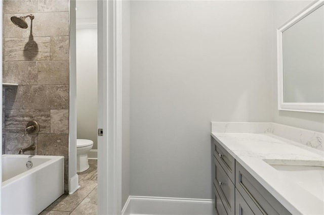 bathroom featuring toilet, vanity, and baseboards