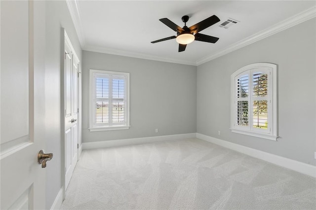 empty room featuring baseboards, visible vents, and crown molding