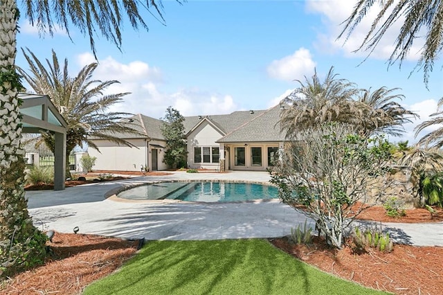 outdoor pool featuring a patio and a lawn