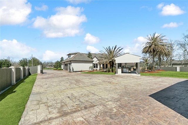 view of front of house featuring a gazebo, a front lawn, a patio, and fence