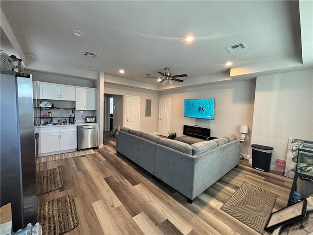 living room featuring a ceiling fan, visible vents, dark wood-type flooring, and recessed lighting