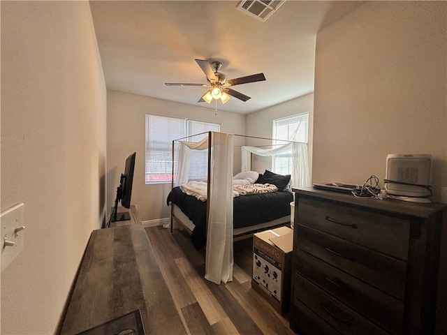 bedroom featuring a ceiling fan, baseboards, visible vents, and dark wood-type flooring