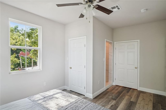 unfurnished bedroom featuring ceiling fan, dark wood-style flooring, visible vents, and baseboards