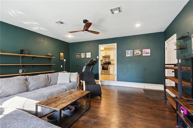 living area with ceiling fan, wood finished floors, visible vents, and baseboards