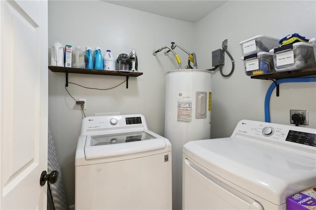 laundry room featuring laundry area, washing machine and dryer, and water heater