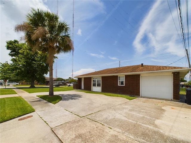 view of front of property featuring driveway, brick siding, a front lawn, and an attached garage