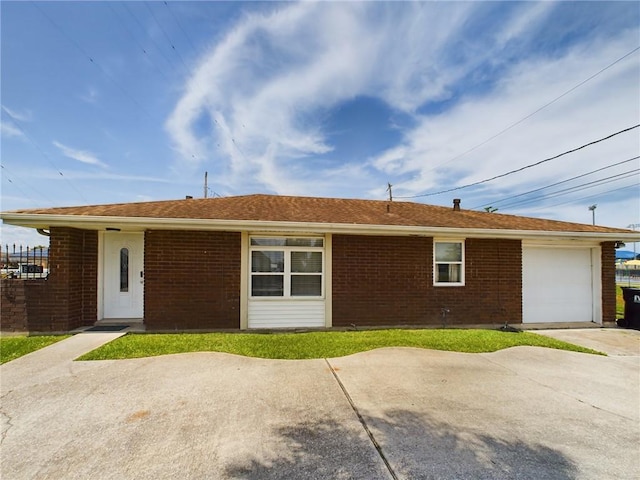 single story home featuring a garage, concrete driveway, and brick siding