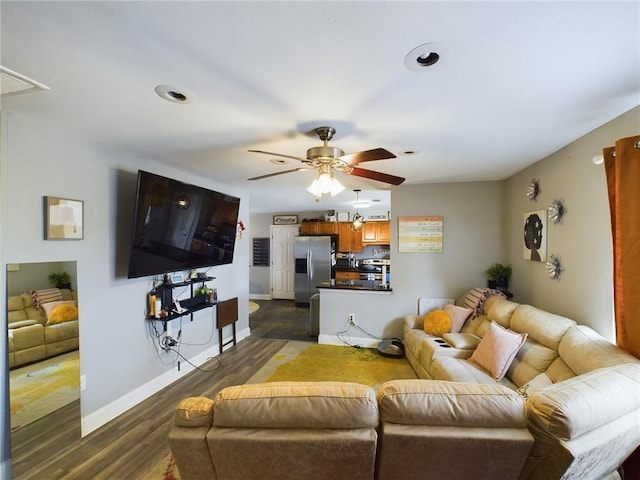 living room featuring ceiling fan, baseboards, and dark wood finished floors