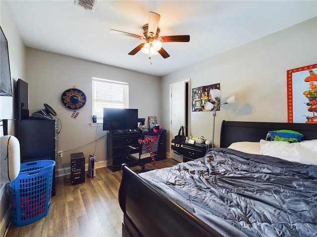 bedroom with dark wood-style floors, baseboards, visible vents, and a ceiling fan