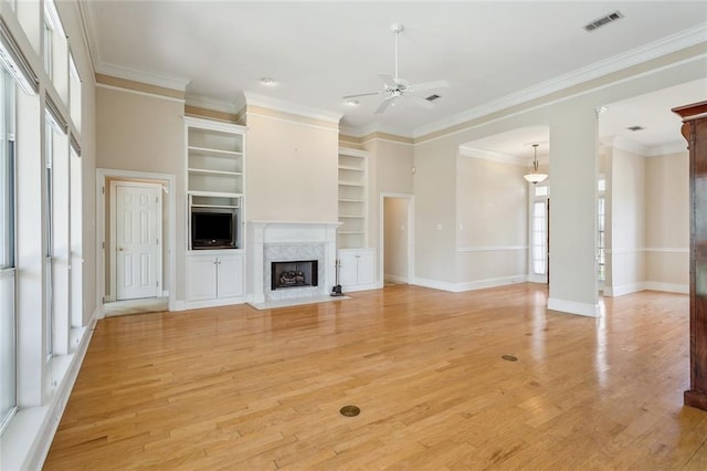 unfurnished living room with visible vents, ceiling fan, ornamental molding, and light wood-style flooring