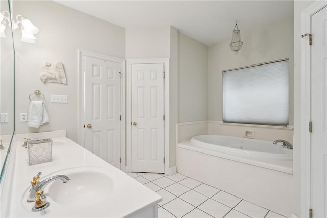 bathroom with a sink, a garden tub, double vanity, and tile patterned flooring