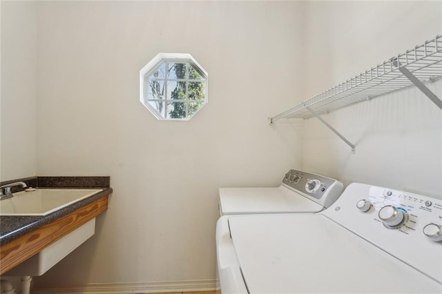 laundry room with laundry area, a sink, and separate washer and dryer