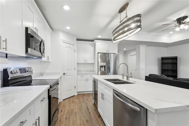 kitchen with light wood-style floors, white cabinetry, stainless steel appliances, and a sink