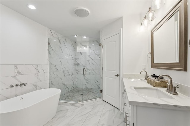 full bathroom with marble finish floor, a freestanding tub, a sink, and a marble finish shower