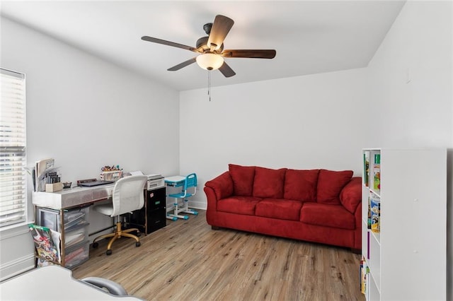 office space featuring baseboards, a ceiling fan, and wood finished floors