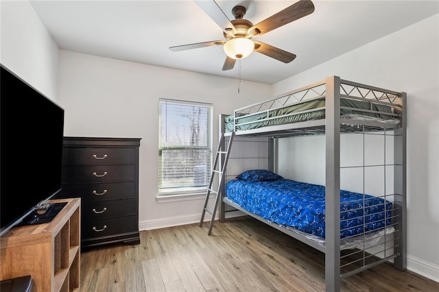 bedroom featuring light wood-style flooring, baseboards, and ceiling fan