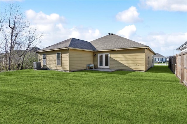 rear view of house featuring central AC, french doors, a lawn, and fence