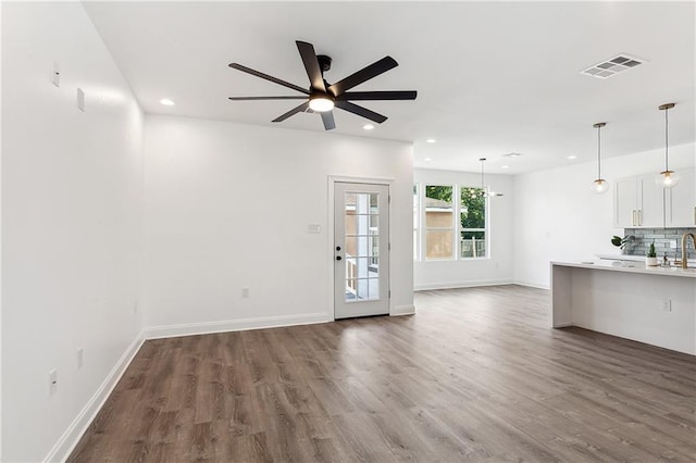 unfurnished living room featuring recessed lighting, visible vents, ceiling fan, wood finished floors, and baseboards