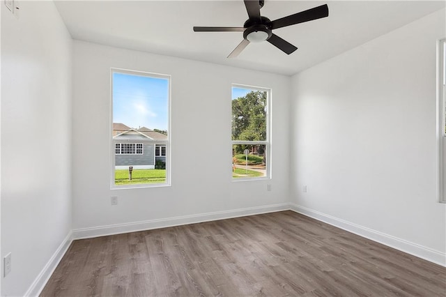 spare room with a ceiling fan, baseboards, and wood finished floors